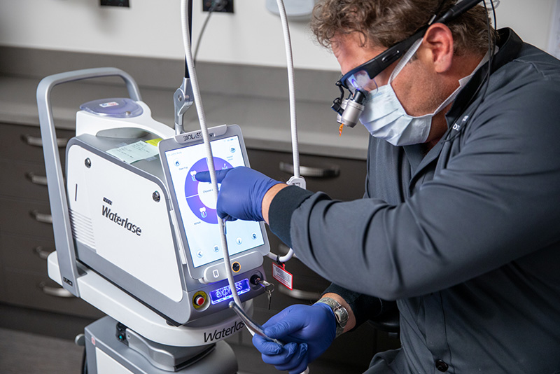Prosthodontist Dr. Dean Kois configuring a Biolase Waterlase laser before periodontal treatment.