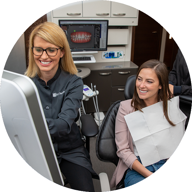 Orthodontist Dr. Brienne Roloff and female invisalign patient looking at a monitor.