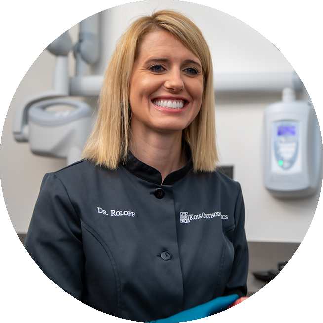 Orthodontist Dr. Brienne Roloff smiling and standing in front of a cbct scanner.